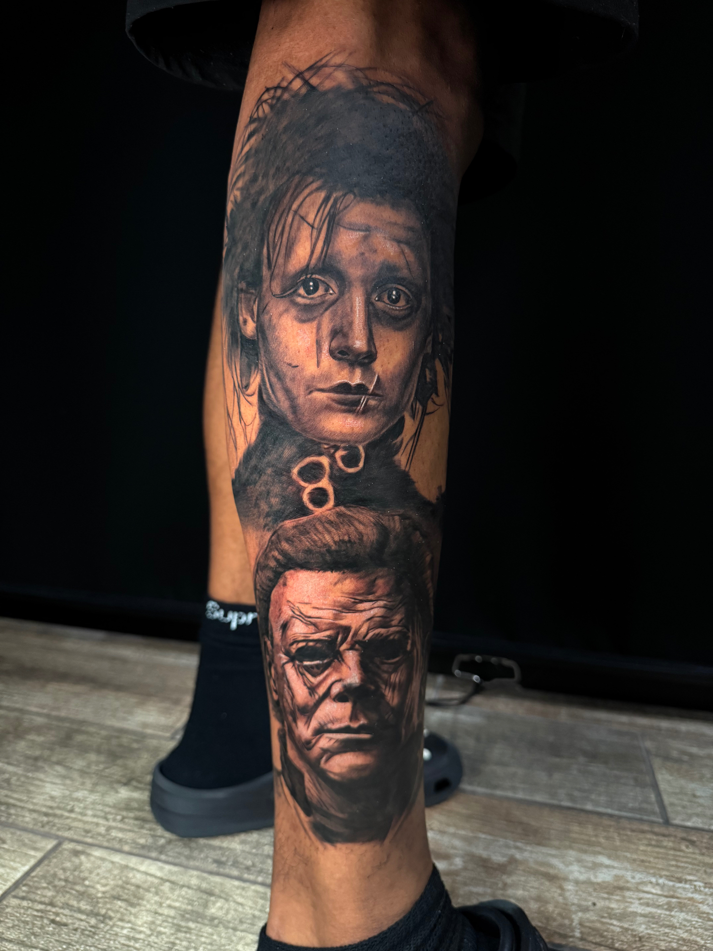 Black and grey leg tattoo featuring Edward Scissorhands and Michael Myers portraits